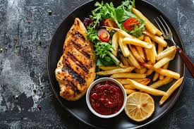 Pollo a la parrilla con papas fritas y verduras salteadas